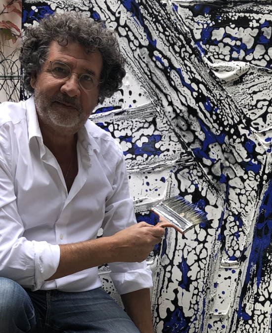 L'artiste Avner en Bretagne dans sa galerie de Pont-Aven devant un de ses tableau abstrait
